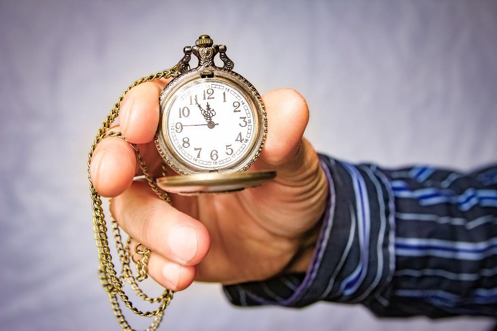 Close up shot of a hand holding an antique pocket watch